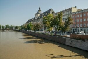 Scenic view of University of Wrocław by the Odra River, capturing the architectural beauty and vibrant city life.